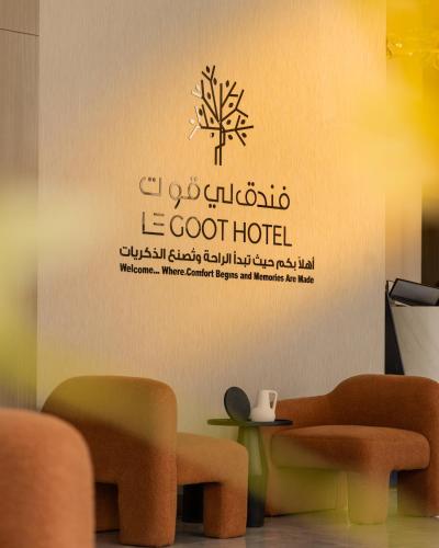 a room with a sign on a wall with a table and chairs at LEGooT HOTEL in Khamis Mushayt