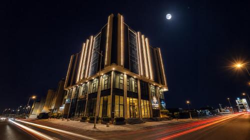 a large building at night with the moon behind it at LEGooT HOTEL in Khamis Mushayt