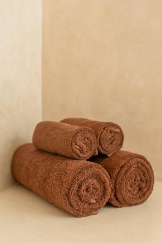 a stack of brown towels sitting on a table at Julie House Lombok in Ekas