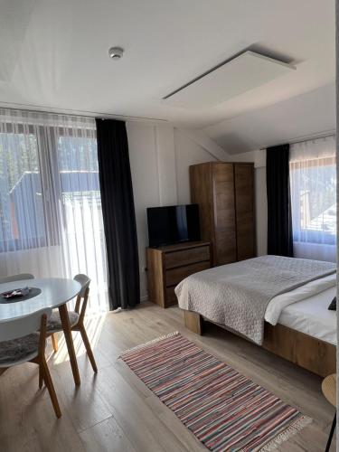 a bedroom with a bed and a table and a tv at MONTANA in Jahorina