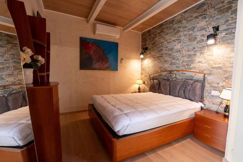 a bedroom with two beds and a stone wall at Casa Dimonte in San Siro