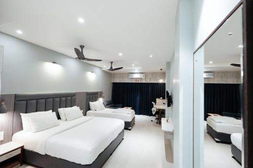 a hotel room with two beds and a desk at Hotel Lee Garden Near to Blue Flag Beach 500 Mtrs in Puri