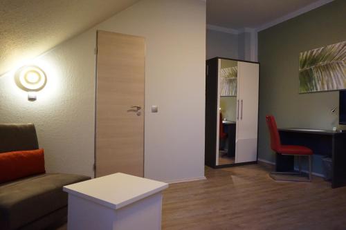 a living room with a couch and a table and a mirror at Hotel-Restaurant Große-Wilde in Bottrop