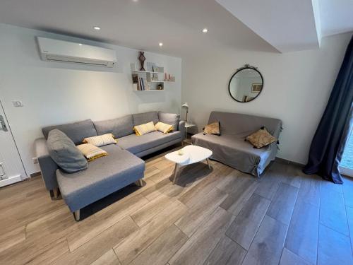 a living room with two couches and a table at Les Coustelines Piscine privée et Jacuzzi in Forcalquier