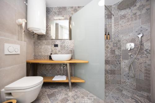 a bathroom with a toilet and a sink and a shower at Hotel - Teranea City Hvar in Hvar