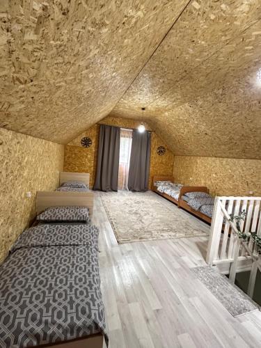 a room with four beds in a room with a ceiling at Kolsay Amanat Resort in Kurmenty
