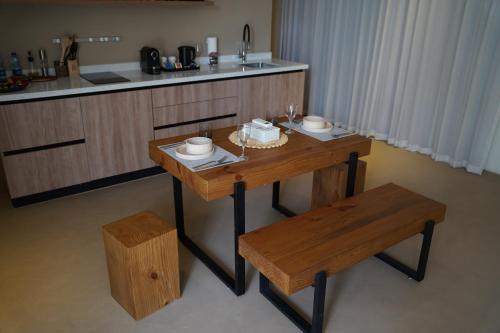 a wooden table and bench in a kitchen with a counter at Wabas Al Fanar in Rumays