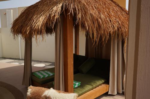 a room with a bed with a grass umbrella at Wabas Al Fanar in Rumays
