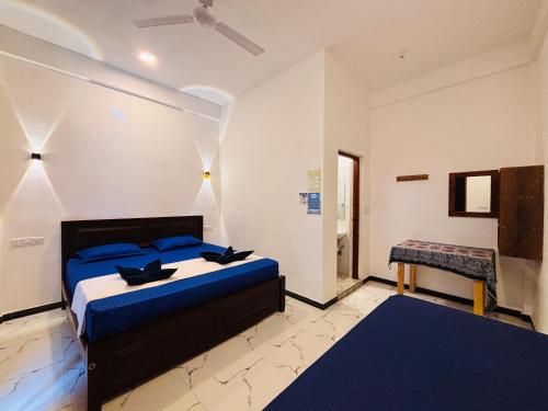 a bedroom with a bed and a table in it at Baywatch Arugambay in Arugam Bay