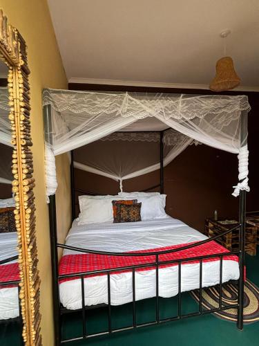 a bedroom with a canopy bed and a mirror at Balletto Boutique in Arusha