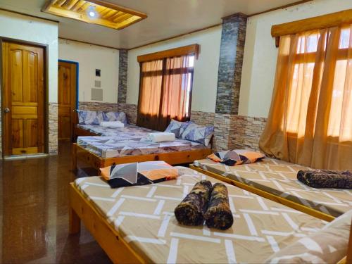 a group of four beds in a room at Mountain Lodge within Town Proper! in Sagada