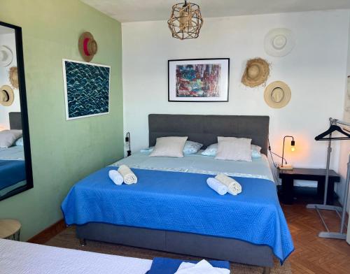 a bedroom with a blue bed with towels on it at Beach House Hvar in Zastražišće