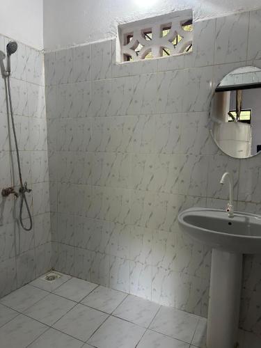 a white bathroom with a sink and a mirror at Warembo beach Nungwi in Nungwi