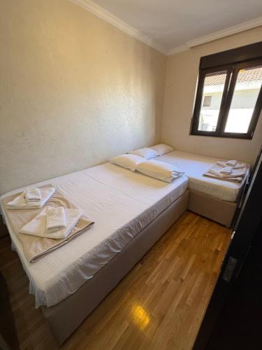 two twin beds in a room with a window at Apartman ML Company in Bečići