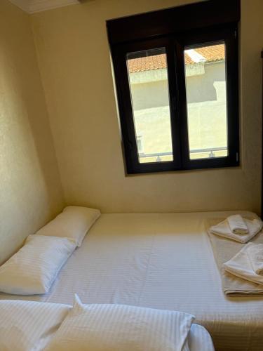 two beds in a room with a window at Apartman ML Company in Bečići