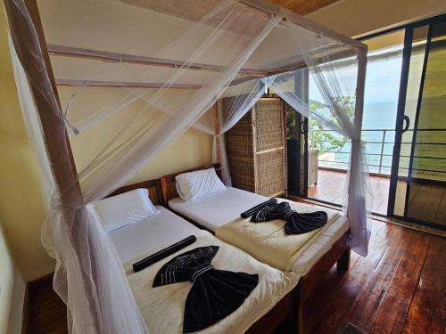 two beds in a room with a window at Nyanja Cottage in Chembe