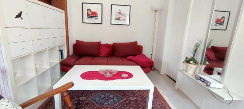 a living room with a red couch and a table at Apart Königseiche in Goldenstedt