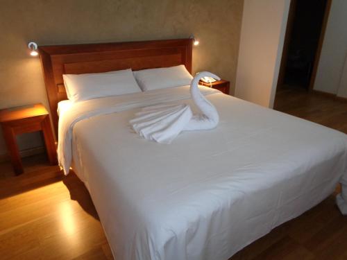 a white swan sitting on top of a bed at Hotel Villa De Betanzos in Betanzos