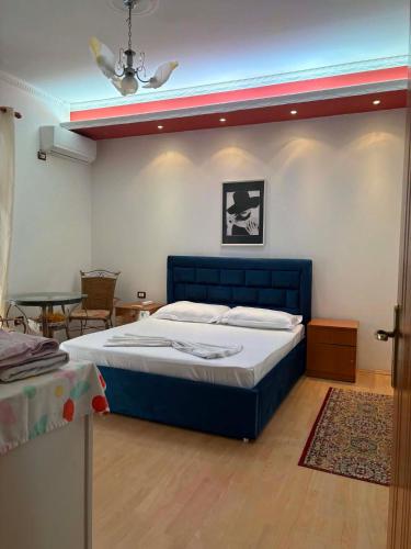 a bedroom with a blue bed and a table at Villa Klinton in Durrës