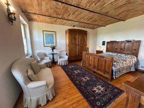 a bedroom with a bed and a couch and chairs at Casa Molisso in Montegrosso dʼAsti