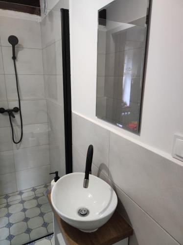 a white sink in a bathroom with a shower at Odpocznij -apartament nad jeziorem in Rydzewo