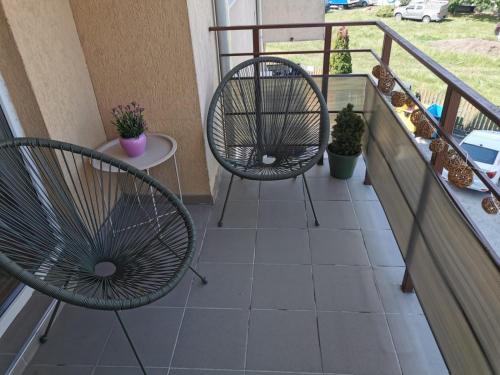 two chairs and a table on a balcony at Flower Apartment in Floreşti