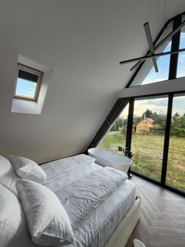 a bedroom with a bed and a tub and a window at LUMA Lodge in Sadu