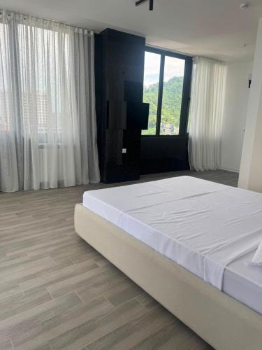a bedroom with a large bed and a large window at Thom Tower in Gonio