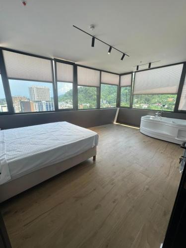 a large bedroom with a bed and a bath tub at Thom Tower in Gonio