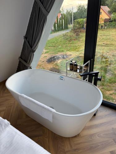 a white bath tub in a room with a window at LUMA Lodge in Sadu