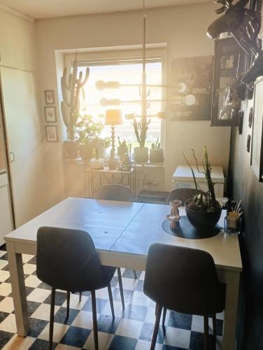 a dining room table with two chairs and a table with plants at The Creative Studio Apartment in Piteå
