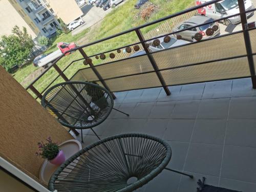 a balcony with two chairs and a bench at Flower Apartment in Floreşti