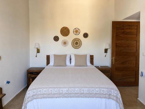 a bedroom with a bed and plates on the wall at Leonidas house hydra in Hydra