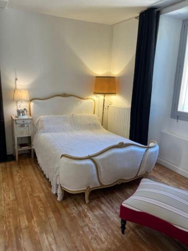 a bedroom with a large bed and a window at Grand appartement de charme avec parking privé in Florac