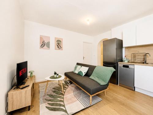 a living room with a couch and a kitchen at 8A - Le Nid in Saint-Rambert-dʼAlbon