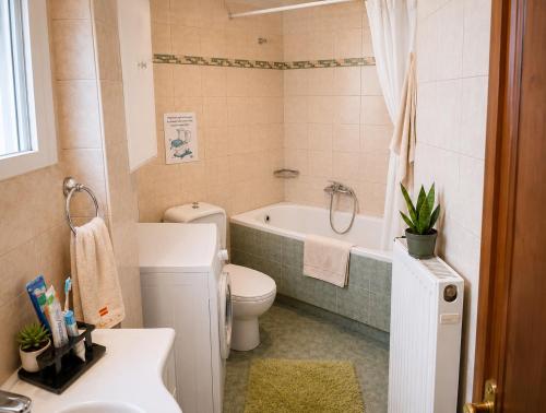 a bathroom with a toilet and a tub and a sink at HOUSE WITH GARDEN Netflix in Néa Kerasiá