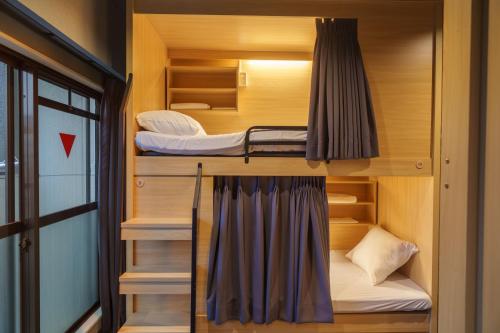 a couple of bunk beds in a small room at Bonsai Cafe and Stay - B&B Dormitory in Tokyo