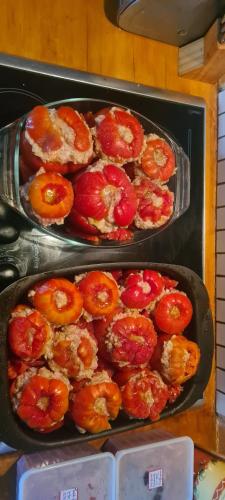 two trays of food on a stove with tomatoes at Havre de tranquilité en Chartreuse in Saint-Étienne-de-Crossey