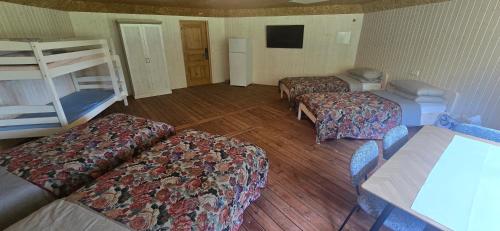 a room with three beds and a bunk bed at Mäe Puhkemaja in Rosma