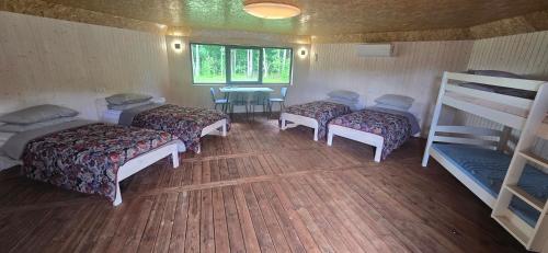 a room with four bunk beds and a table at Mäe Puhkemaja in Rosma