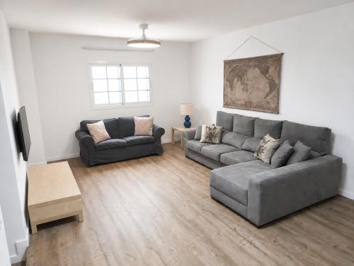 a living room with two couches and a table at Sardina Beach Retreat in Gáldar