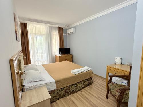 a bedroom with a bed and a desk and a window at Mini Hotel "Arystan" в самом центре столицы in Astana