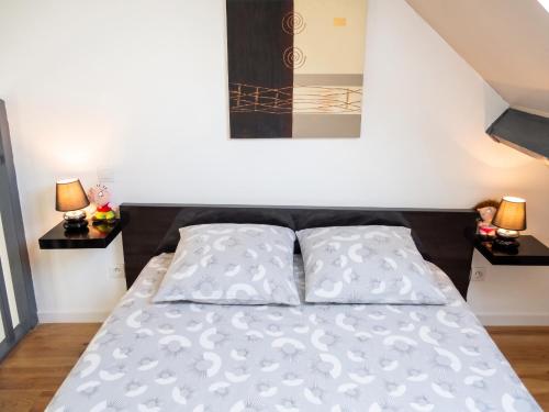 a bed in a bedroom with two pillows at Studio confortable à Pédernec - 27m² - Terrasse ensoleillée in Pédernec