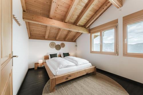 a bedroom with a bed in a room with wooden ceilings at Bergchalet mit Panoramablick nahe Brienz in Axalp