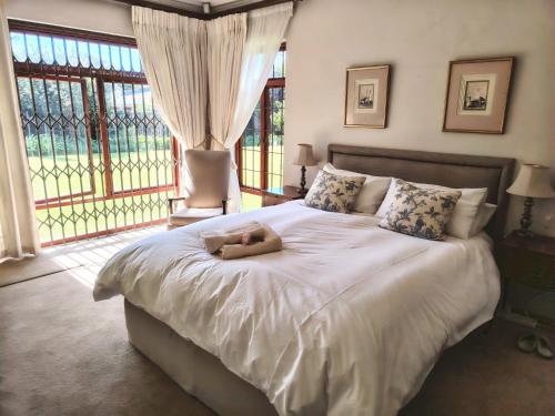 a teddy bear laying on a bed in a bedroom at Francolin's Rest Guest Suite in Sweet Valley