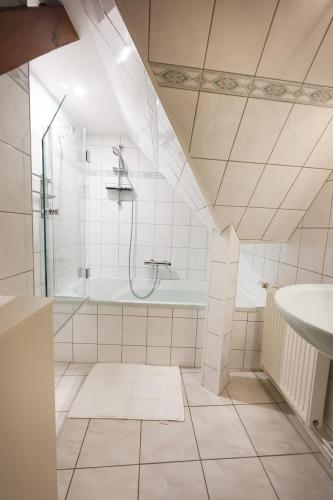 a bathroom with a shower and a tub and a sink at Gîte sous le toit du vigneron in Epfig