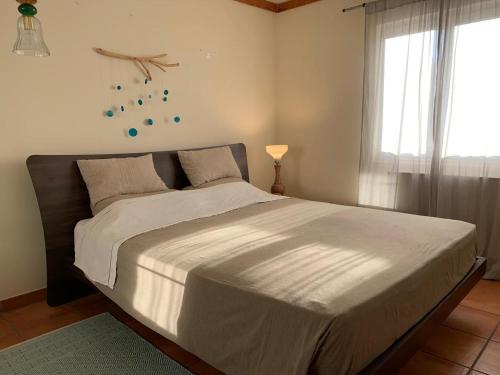 a large bed in a bedroom with a window at Aldeamento Turistico Casas da Comporta in Comporta