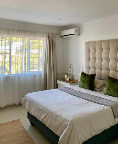 a bedroom with a large bed and a window at The Willow Escape in Ballito