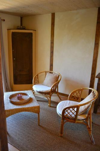 a living room with two chairs and a table at La Parenthèse Béarnaise in Bonnut