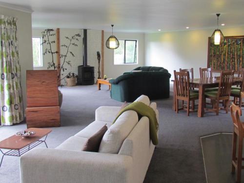 a living room with a couch and a dining room at Rolling Hills Country Stay B&B in Tauranga